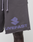 Close-up of a person wearing LIVE FAST DIE YOUNG Live Fast LF Shorts in dark gray, featuring a purple geometric logo and LIVEFAST text on the left leg, wide fit with visible elastic waistband, raw edges, and practical side pockets.