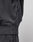 Close-up of a person wearing a dark gray LFDY 40 Hooded sweatshirt by LIVE FAST DIE YOUNG with matching pants. A small fabric tag is visible on the side seam, and the top features a subtle kangaroo pocket. The background is plain and light-colored.