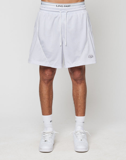 A person in LFDY Piping Mesh Shorts by LIVE FAST DIE YOUNG, featuring a white mesh design, LIVE FAST Elastikbund waistband, small logo near the hem, white crew socks, and sneakers stands against a plain background.
