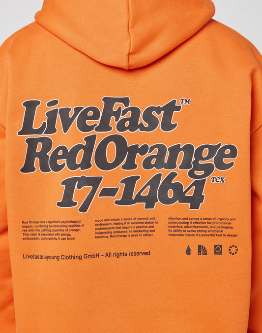 Model wears the LIVE FAST DIE YOUNG Basic Orange Hooded, crafted from soft cotton and polyester, with bold black and white LiveFast Red Orange 17-1464 print on front and back, plus additional small detail accents.
