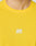 Close-up of a person wearing the LIVE FAST DIE YOUNG Live Fast Performance Longsleeve in bright yellow, featuring a white LIVE FAST logo and reflective front print on the chest. The slim fit highlights their build; neck and chin are visible.