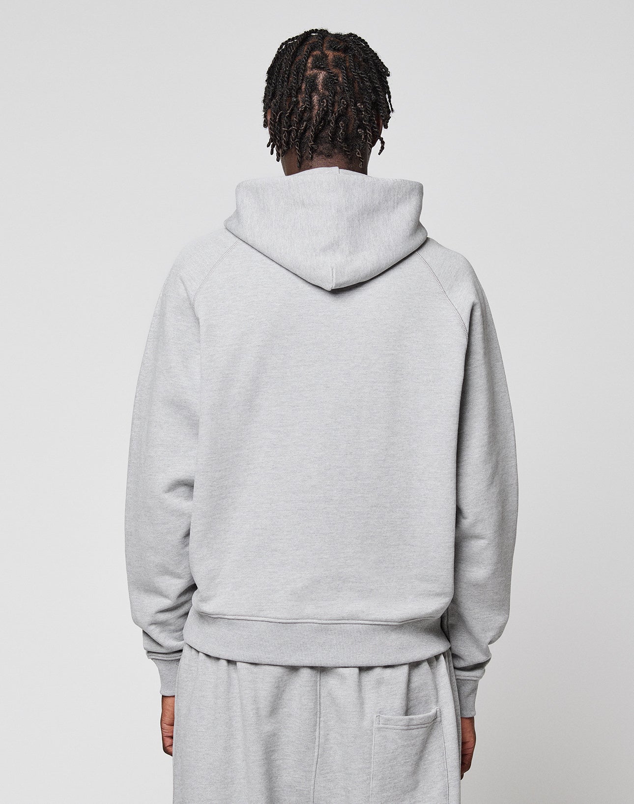 A person with short, twisted hair is facing away from the camera, wearing a light gray LIVE FAST DIE YOUNG LFDY Embroidery Hooded and matching sweatpants against a plain white background.