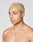 A person with short, bleached blonde hair and medium skin tone looks to the side. They are shirtless, wearing a LIVE FAST DIE YOUNG LFDY Praying Chain necklace with pendant and a small gold hoop earring. Background is plain and light-colored.