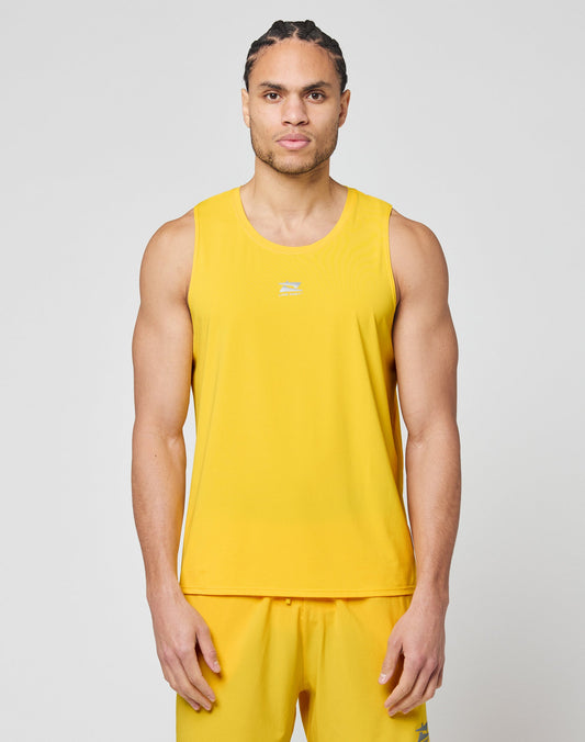A man with braided hair wears the LIVE FAST DIE YOUNG Live Fast Performance Tank and matching yellow shorts with reflective print, standing against a plain light gray background. | model