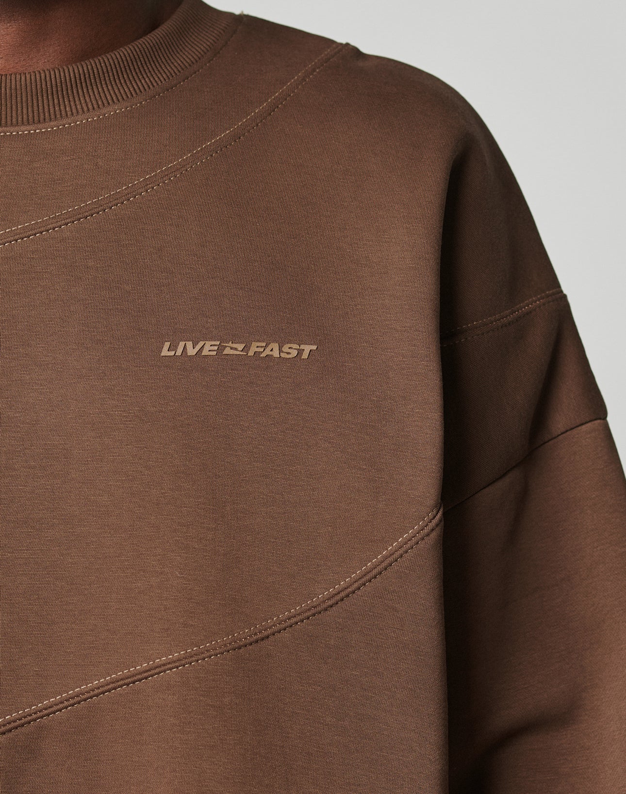 Close-up of the LFDY Wavy Sweater by LIVE FAST DIE YOUNG, featuring soft Baumwolle-blend fabric, diagonal seam accents, LIVE FAST in subtle chest text, and an Oversize Fit emphasized on the upper torso.