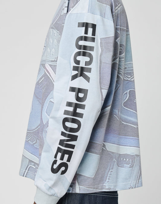 A person in the LFDY Stolen Phones Longsleeve by LIVE FAST DIE YOUNG, a light blue oversize-fit shirt with bold black FUCK PHONES sleeve print and vintage-inspired old telephone graphics.