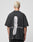 A person with short blonde hair, seen from behind, wears the LIVE FAST DIE YOUNG LFDY Flip Phone Tee, a black oversized cotton shirt featuring a large open flip phone graphic with the slogan “No tellin’ on the phone.”.