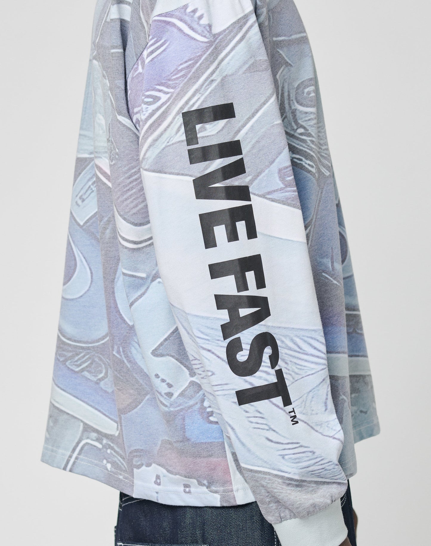 A person wears the LFDY Stolen Phones Longsleeve by LIVE FAST DIE YOUNG, featuring overlapping sneaker graphics and bold black LIVE FAST print on the sleeve. The visible upper body highlights the shirts unique style.