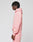 A person with short, twisted hair wears the oversize fit Basic 360 Hooded by LIVE FAST DIE YOUNG in pink with matching sweatpants, featuring topstitching, standing in profile against a plain light gray background.