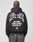 A person faces away from the camera wearing a black, oversized LIVE FAST DIE YOUNG Live Fast Lenox Hooded Zip, made of Baumwolle, with bold front and back prints including JIM JONES LENOX AVENUE HARLEM, NY and a small American flag on the back.