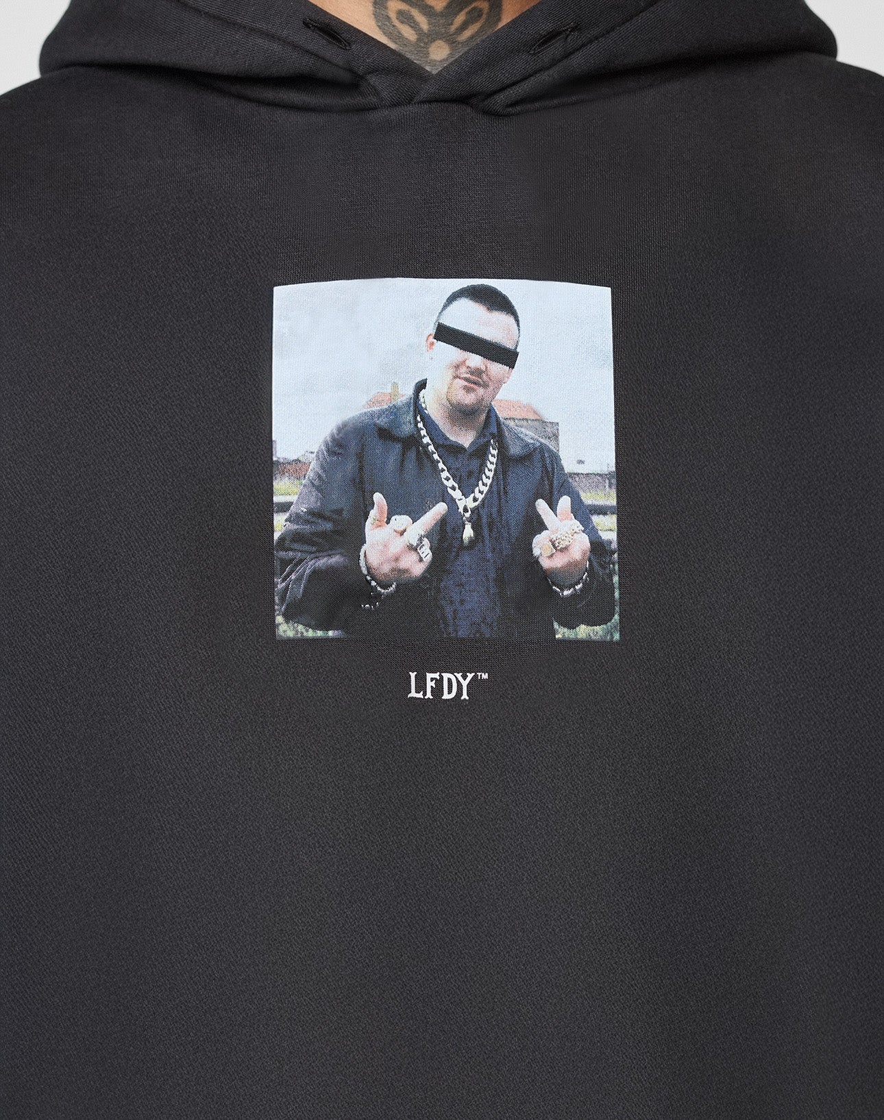 The LFDY Gambling Hooded by LIVE FAST DIE YOUNG is a black hoodie with a bold front print: a man in jewelry and leather jacket, eyes censored, showing both middle fingers. Oversized fit, 360 GSM fabric, and LFDY text below the image ensure comfort and style.
