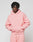 Wearing an oversize fit light pink Basic 360 Hooded sweatshirt and matching sweatpants from LIVE FAST DIE YOUNG, a person stands with hands in the pocket, looking at the camera. The hoodie has topstitching and small LiveFast text on the chest.