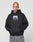 A person with a shaved head, tattoos, and neutral expression wears the LIVE FAST DIE YOUNG LFDY Gambling Hooded—a black oversize 360 GSM hoodie with a bold front photo print—standing against a plain light gray background with hands in the pocket.