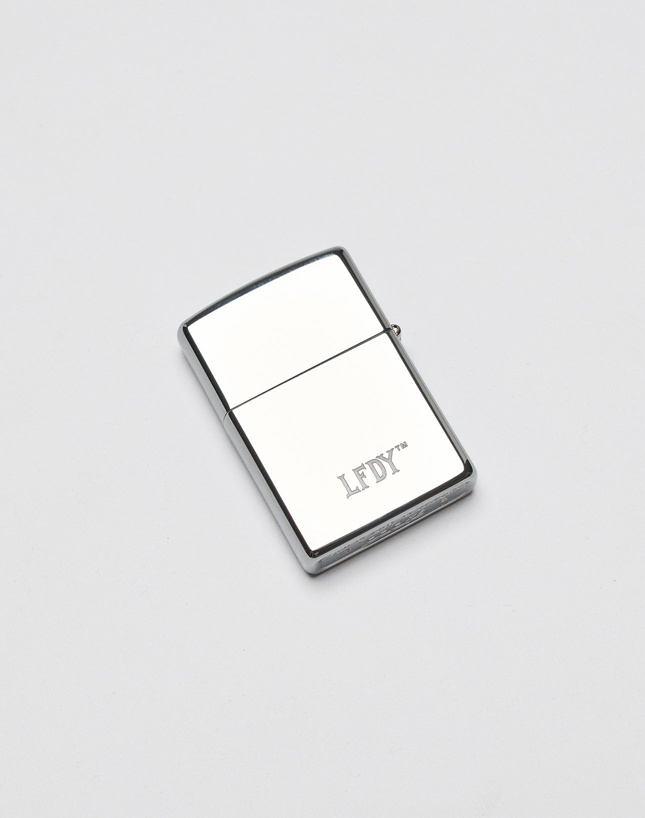 The LFDY x Zippo lighter by LIVE FAST DIE YOUNG features a silver rectangular Aluminium-Gehäuse with LFDY engraved on the front, shown on a plain white background.