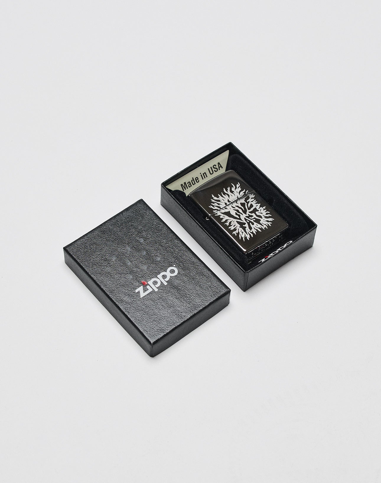 A black Zippo box, partly open, displays the LFDY x Zippo by LIVE FAST DIE YOUNG—Limited Edition Feuerzeug with tree design and Made in USA label inside its aluminium case on a plain white background.