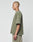 A person with a shaved head and visible tattoos wears the LIVE FAST DIE YOUNG Basic +49 Chest Tee in olive green with beige shorts, standing in profile against a plain light background.