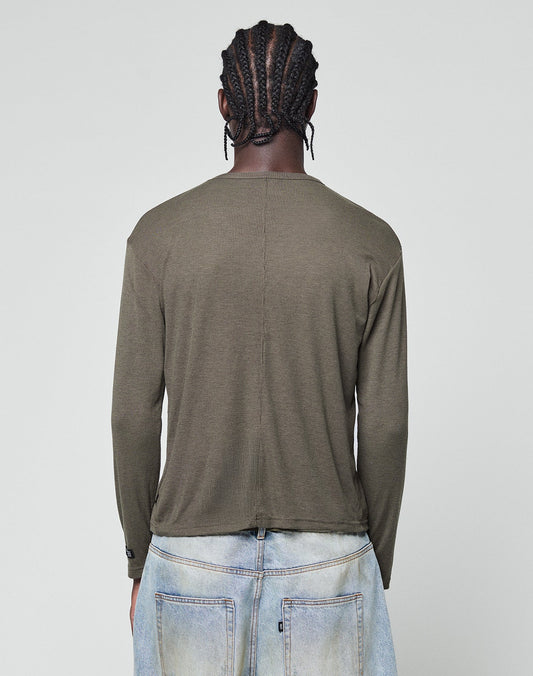 A person with braided hair is seen from behind wearing the LIVE FAST DIE YOUNG LFDY Rib Longsleeve in olive-green and light blue jeans, standing against a plain light gray background.