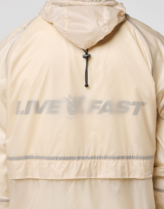 A close-up shows the back of the Live Fast Nylon Jacket by LIVE FAST DIE YOUNG, featuring a reflective "LIVE FAST" print in bold letters and a black drawstring beneath the hood, accentuating its light beige transparent nylon fabric.