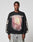 A man wears the LFDY Angel Sweater by LIVE FAST DIE YOUNG—an oversized black Baumwolle sweatshirt with LIVE FAST text above a vibrant graphic and bold OR DIE BY IT text on the sleeves, standing against a plain light background.