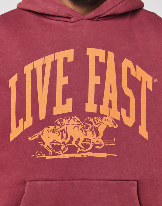 The Live Fast Stallion Hooded by LIVE FAST DIE YOUNG is a maroon, oversized hoodie with a bold yellow front print of two jockeys racing under the words LIVE FAST. Crafted from soft Baumwolle for comfort all day.