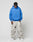 A man stands against a plain background wearing the LIVE FAST DIE YOUNG LFDY F\*ck Phones Hooded in bright blue, paired with light gray camo baggy pants and white sneakers, looking down with his hands in his pockets.
