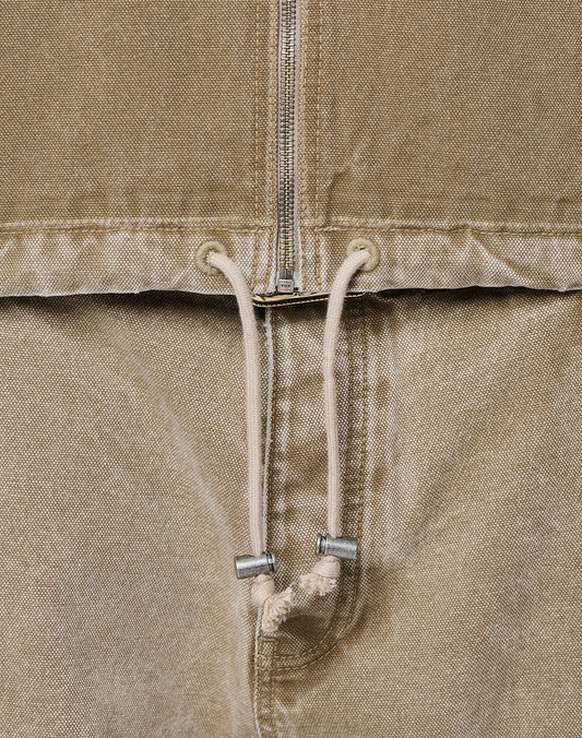 Close-up of the Faded Workwear Jacket by LIVE FAST DIE YOUNG—tan, oversize fit with a metal zipper, kangaroo pocket, metal-tip drawstring, and textured fabric.