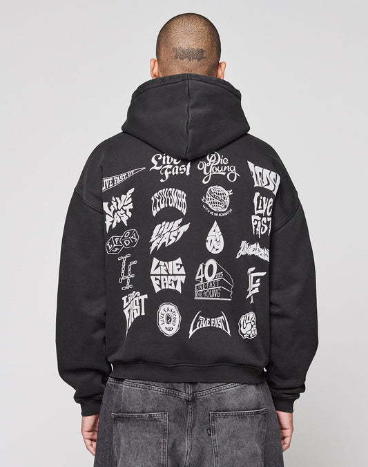 A person faces away from the camera in a black LIVE FAST DIE YOUNG LFDY Logo Hooded Zip, an oversized Baumwolle hoodie with multilogo white graphics and “Live Fast” and “Die Young” phrases on the back, set against a plain gray background. | model
