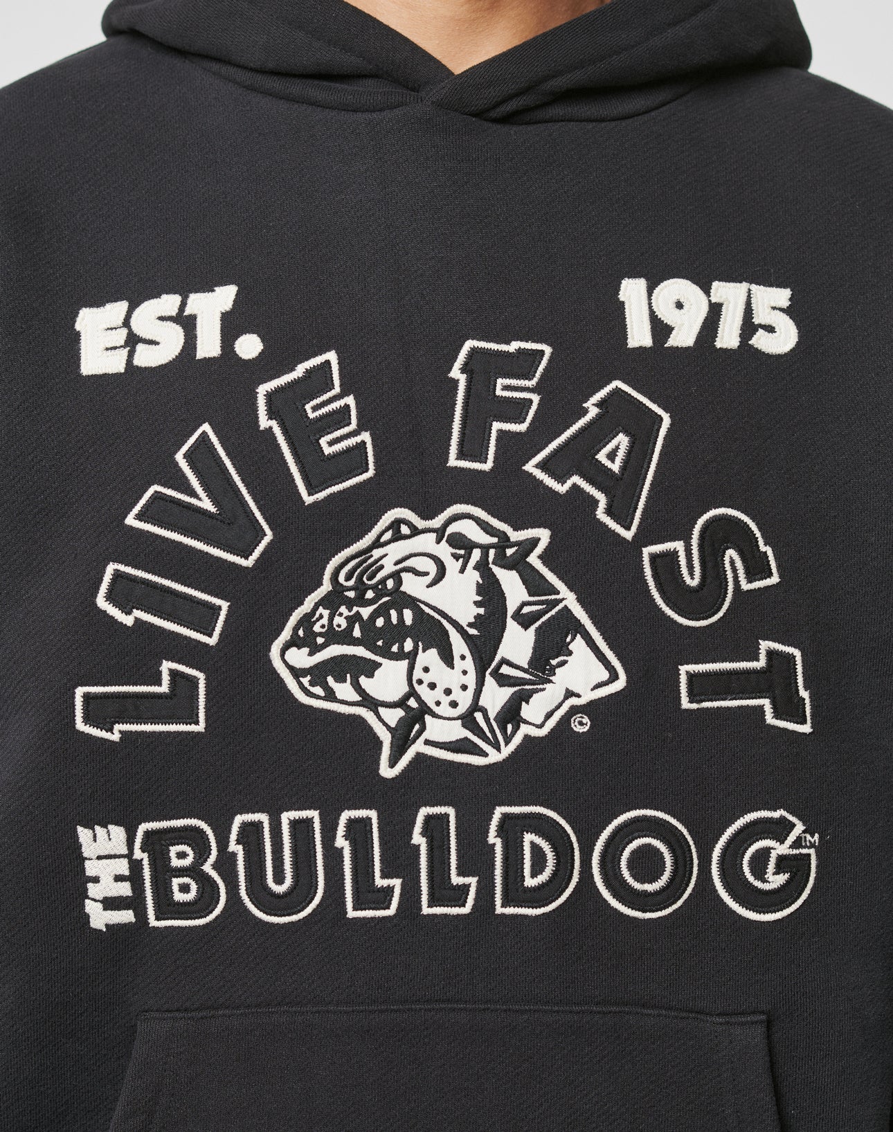 The LFDY The Bulldog Hooded by LIVE FAST DIE YOUNG is a black oversize fit hoodie with EST. 1975, LIVE FAST, THE BULLDOG, and a fierce embroidered bulldog head with spiked collar in white and black.