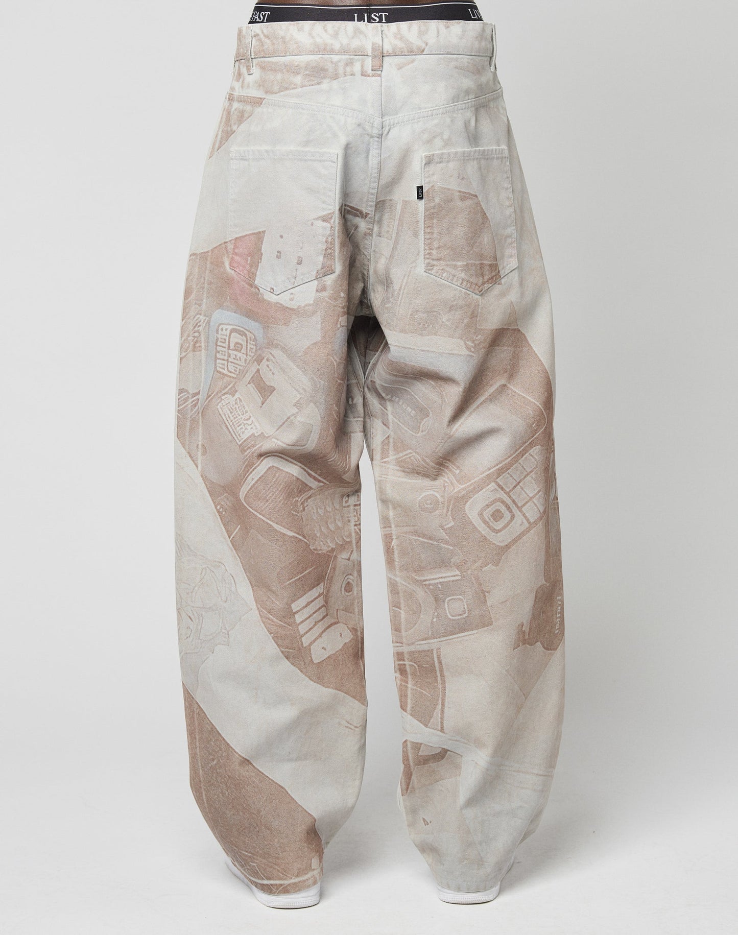 The LFDY Stolen Phones Denim by LIVE FAST DIE YOUNG features baggy, light-colored pants with an all-over print of retro electronics. Shown from the back on a white background. Made from 100% Baumwolle for comfort.