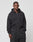 A young man with short braided hair models the LIVE FAST DIE YOUNG Basic 510 Hooded Zip, an oversize black hoodie made from 85% Baumwolle, paired with matching black pants, standing against a white background and facing the camera.