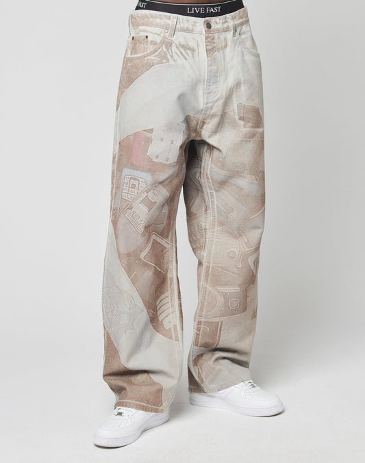 A person wears LFDY Stolen Phones Denim by LIVE FAST DIE YOUNG—baggy fit, 100% cotton, brown and white abstract print—paired with white sneakers. The waistband of black LIVE FAST underwear shows above the jeans.