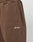 Close-up of the Basic Wide Jogger by LIVE FAST DIE YOUNG featuring brown fabric, a wide elastic waistband, vertical front pocket, wide fit, and white Live Fast embroidery near the hip.