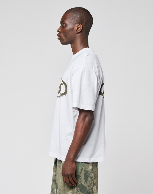 A person stands in profile against a plain background, wearing the oversize LFDY Sphere Tee by LIVE FAST DIE YOUNG with bold front and back prints, paired with green camouflage pants.