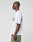 A person stands in profile against a plain background, wearing the oversize LFDY Sphere Tee by LIVE FAST DIE YOUNG with bold front and back prints, paired with green camouflage pants.