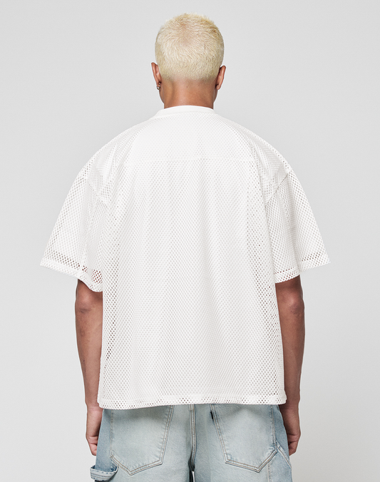 A person with short, bleached blond hair is seen from behind wearing a LIVE FAST DIE YOUNG LFDY Boxy Jersey and light blue denim shorts against a plain gray background.