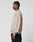 A man in profile against a plain background wears the beige Live For It Sweater by LIVE FAST DIE YOUNG, made from 100% Baumwolle, paired with black pants. His left arm hangs at his side and his expression is neutral.
