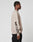 A person stands in profile wearing the LIVE FAST DIE YOUNG Live For It Sweater, an oversized beige sweatshirt with DEFY IT text and a graphic on the sleeve. They pair it with black pants against a plain, light background.