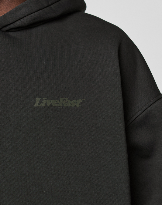 Close-up of the Basic 360 Hooded by LIVE FAST DIE YOUNG: an oversize fit black cotton sweatshirt with subtle "LiveFast" front print and additional print details on front and back. Soft, slightly textured fabric.