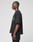 A person stands in profile against a plain background, wearing the LFDY Sphere Tee by LIVE FAST DIE YOUNG—an oversized black Baumwolle T-shirt with subtle front and back prints—paired with black pants. Their arms rest relaxed at their sides.