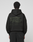 A person wearing the LIVE FAST DIE YOUNG Basic 360 Hooded black hoodie with the hood up, seen from behind. The back showcases large green "LiveFast ArmyGrn 17-0517" text and small writing—a stylish front and back print design.