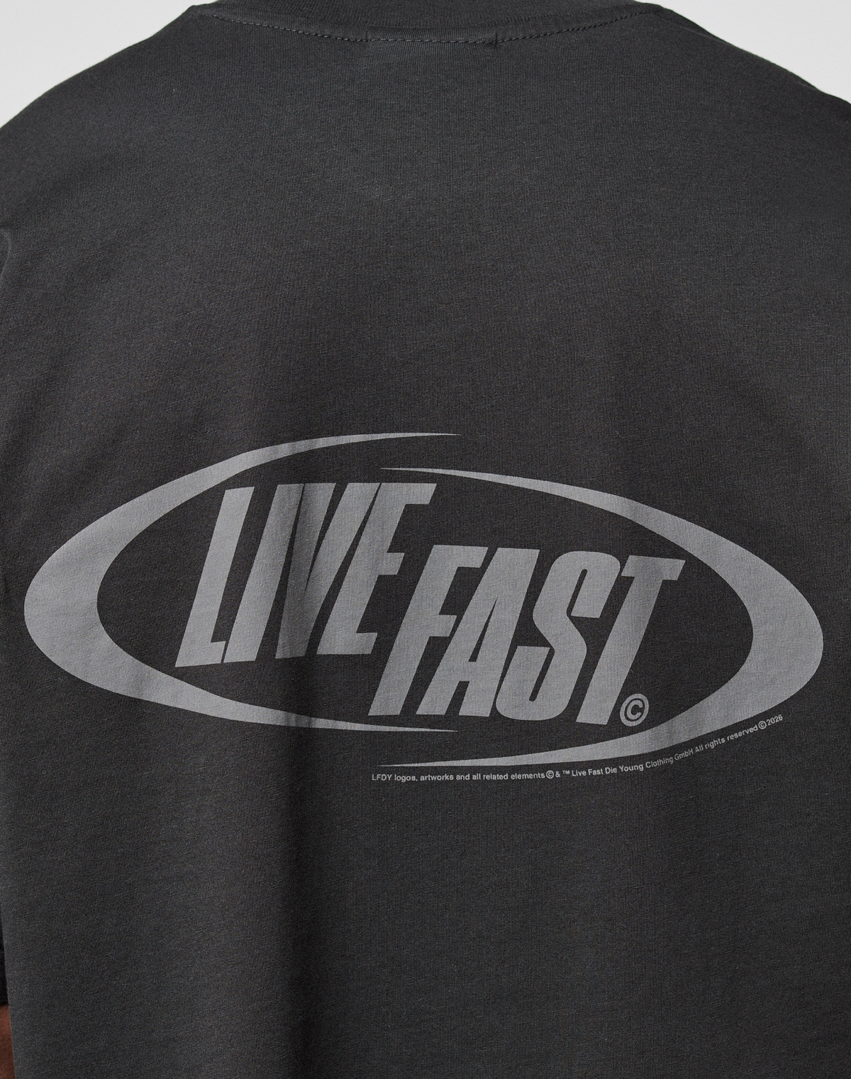 The LFDY Sphere Tee by LIVE FAST DIE YOUNG is a black oversized cotton T-shirt with striking front and back prints, including a large oval graphic and bold light gray LIVE FAST text on the back.
