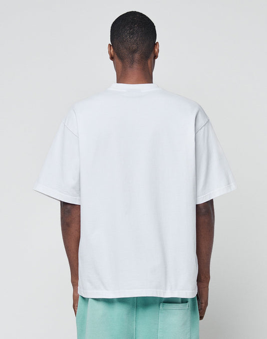 A person faces away from the camera, wearing the LIVE FAST DIE YOUNG Basic +49 Tee in white and mint green shorts, set against a plain light gray background.