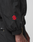 A close-up of a person's arm in the LFDY Dealership Trackjacket by LIVE FAST DIE YOUNG, featuring a red embroidered logo on the sleeve, elastic cuff, gold zippers, and a stylish Stehkragen.