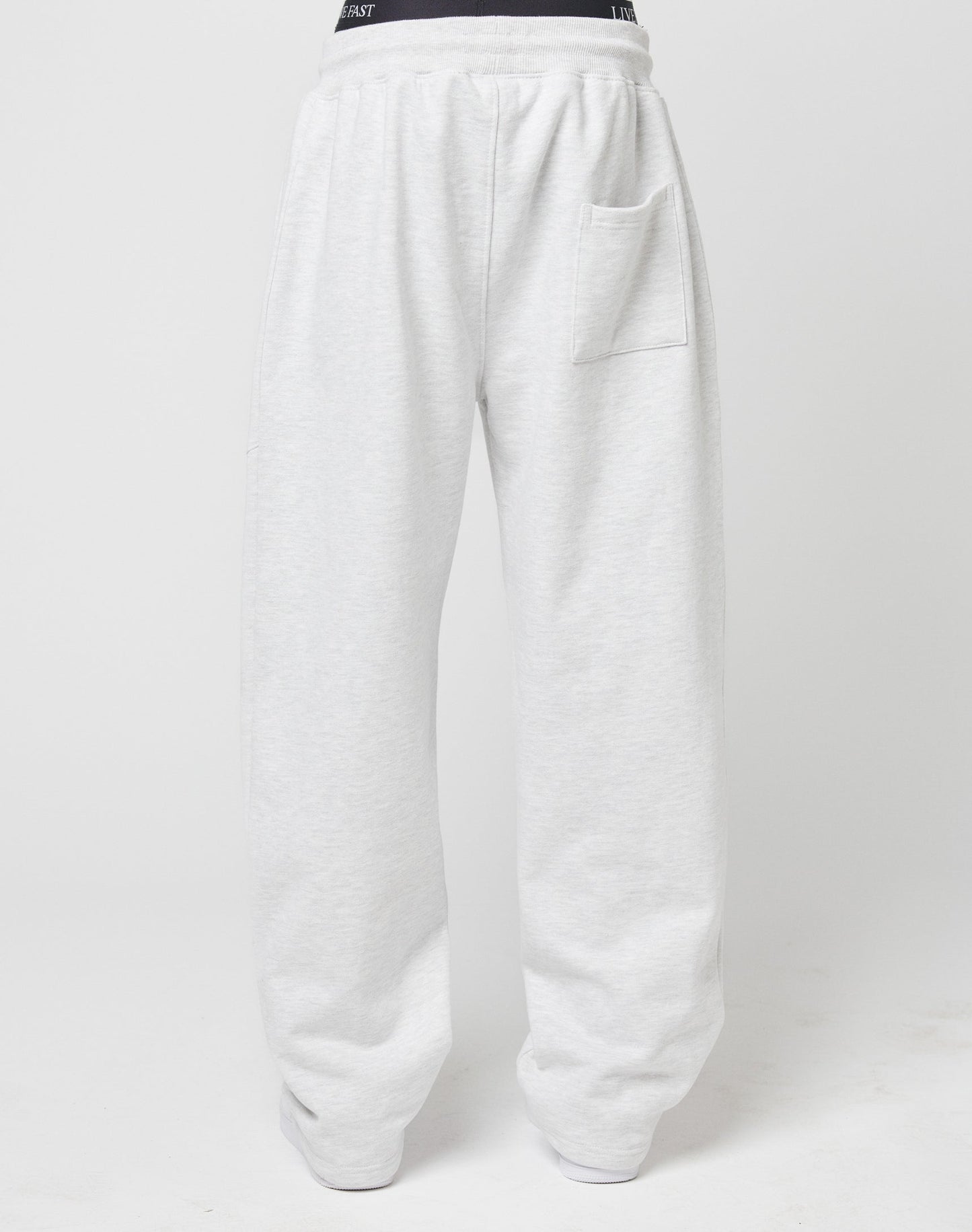 The LIVE FAST DIE YOUNG Basic Wide Jogger features light gray relaxed wide-fit sweatpants with a visible elastic waistband, right thigh side pocket, and straight legs, shown against a plain white background.