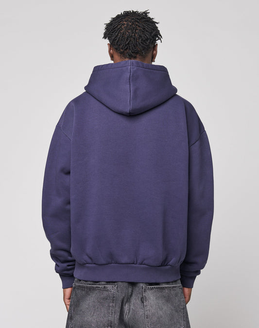Someone is seen from behind, wearing the LIVE FAST DIE YOUNG Live Fast Stallion Hooded in purple (Oversize Fit) and faded gray jeans, set against a plain light gray background.