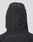 A close-up of the back of the LIVE FAST DIE YOUNG Live Fast Nylon Jacket, an oversized black hooded jacket with a cinch cord and toggle at the hood, shown against a plain light background.