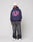A person stands against a plain gray background wearing the LIVE FAST DIE YOUNG Live Fast Stallion Hooded, an oversized navy hoodie with a bold pink LIVE FAST front print, paired with a light pink beanie, baggy dark jeans, and white sneakers.
