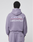 A person is shown from the back wearing an oversized lavender LFDY Hotline Hooded hoodie by LIVE FAST DIE YOUNG with drawstring hood, matching pants, and white CALL US +49LiveFast prints on front and back.