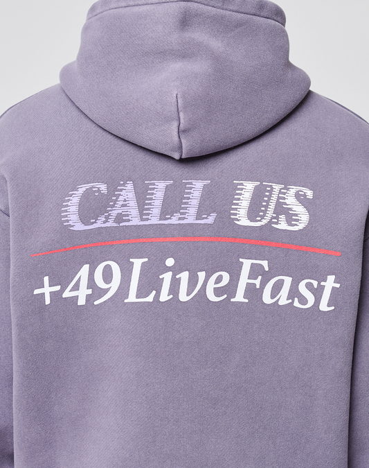 The LFDY Hotline Hooded by LIVE FAST DIE YOUNG is a purple oversized hoodie with front and back prints: "CALL US" in white distorted letters and "+49LiveFast" bold below a red line. It features a hood with drawstrings for a complete look.