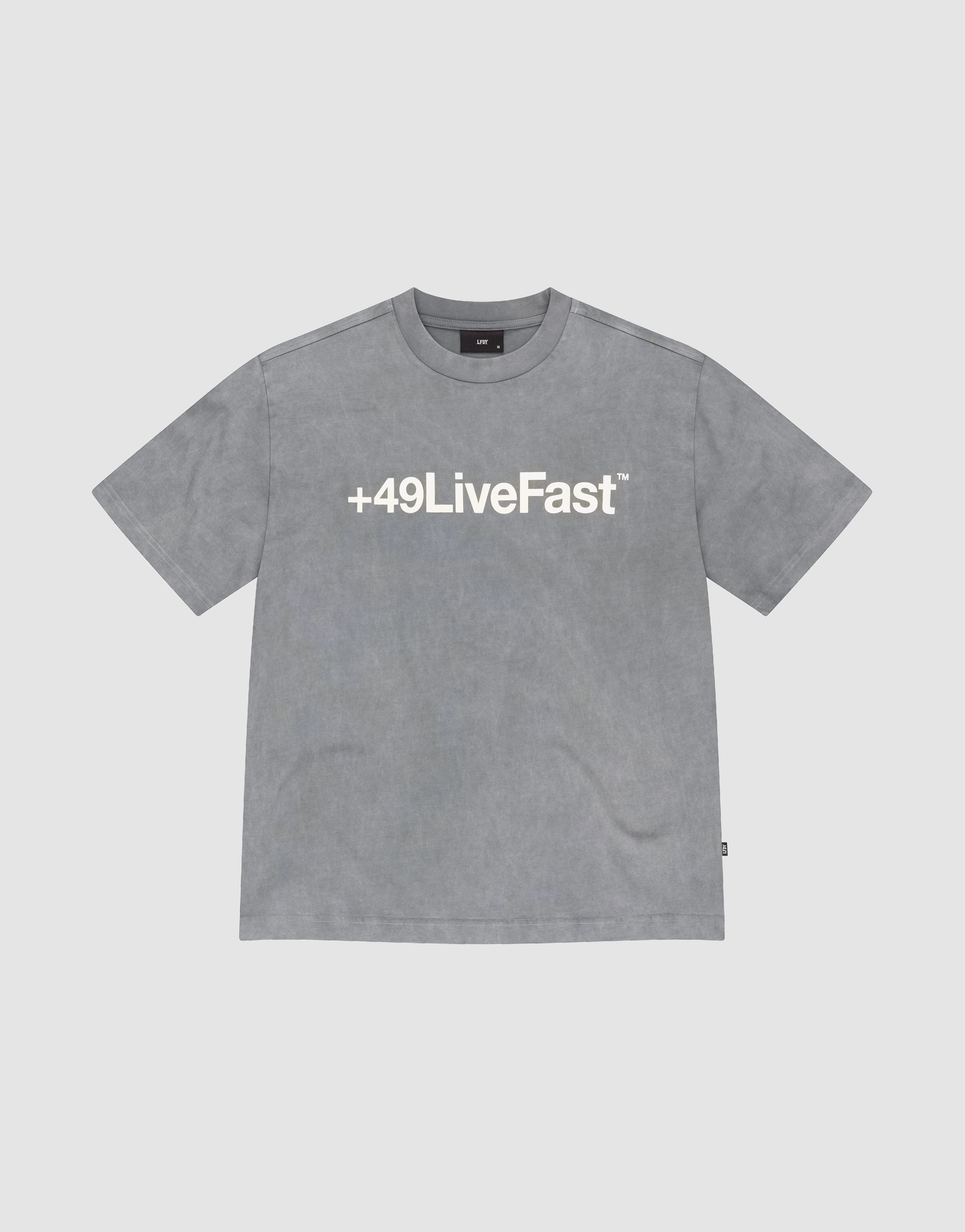 The Basic +49 Tee by LIVE FAST DIE YOUNG is a grey oversized short-sleeve t-shirt featuring a bold white +49LiveFast™ front print, made from 100% cotton and shown on a plain light background. | plain